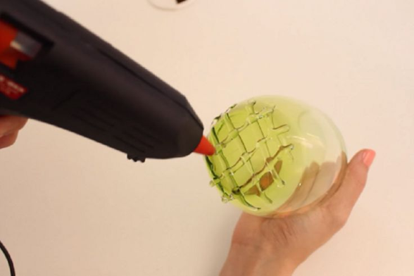 Elle applique de la colle chaude sous un verre